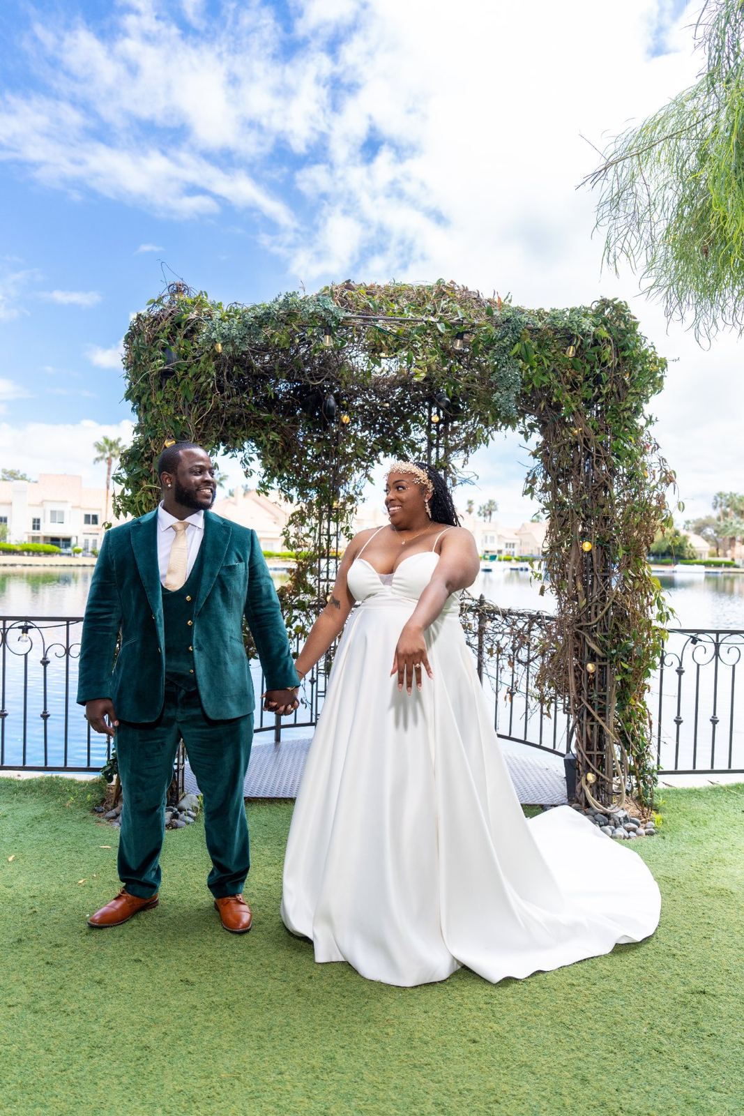Las Vegas wedding photography — the couple under the floral arch against a blue sky