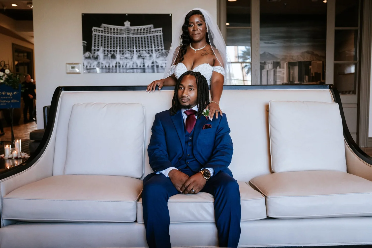 Las Vegas wedding photography — bride and groom on a white sofa, blue suit and maroon tie
