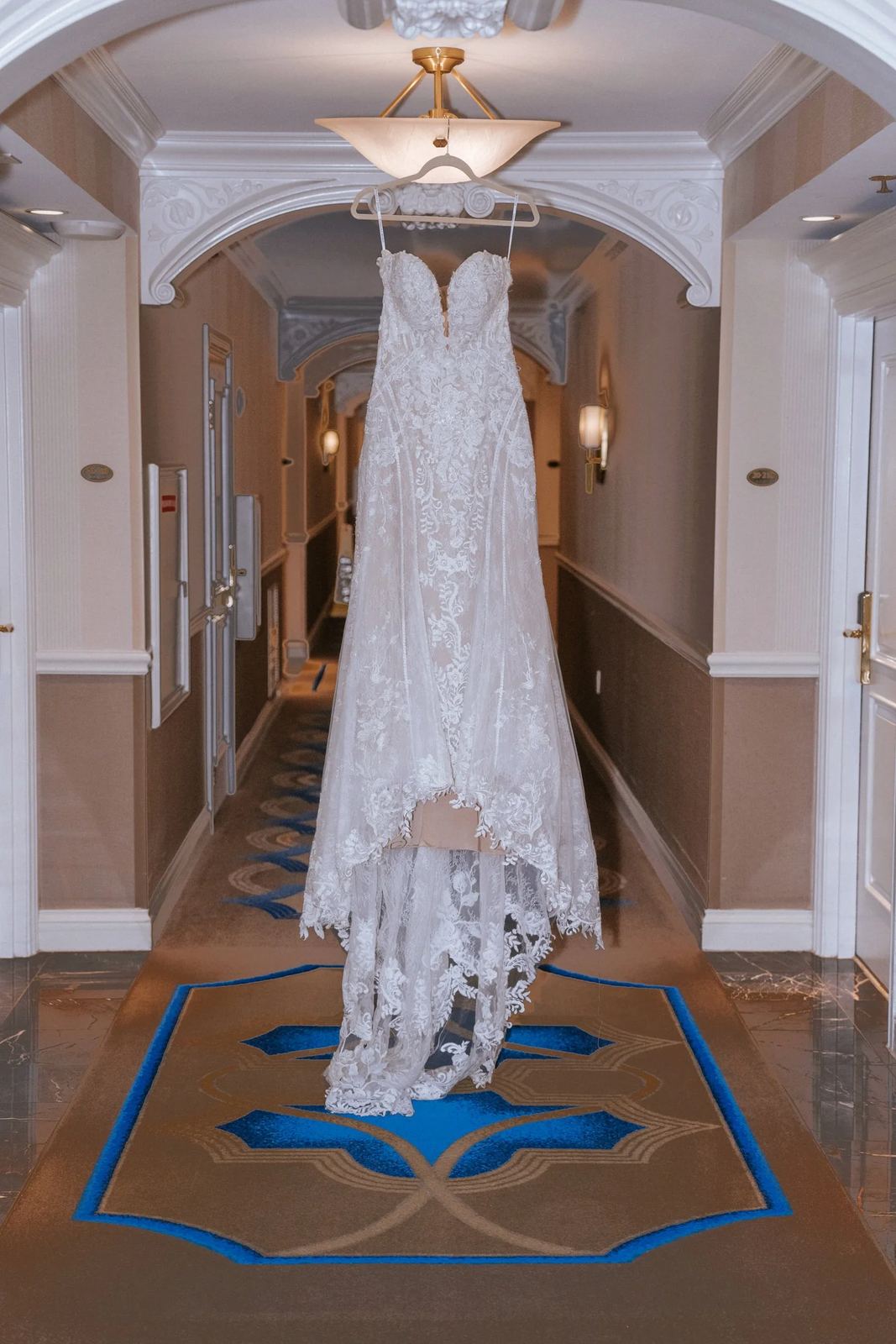 Las Vegas wedding photography — white lace wedding dress hanging in a hotel hallway