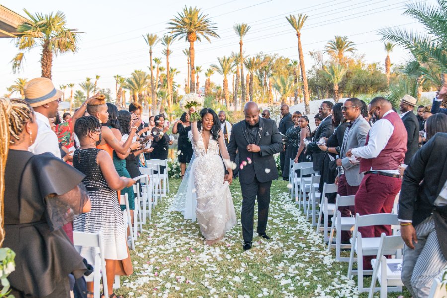 Las Vegas wedding photography — the bride raising her bouquet in celebration on the recessional