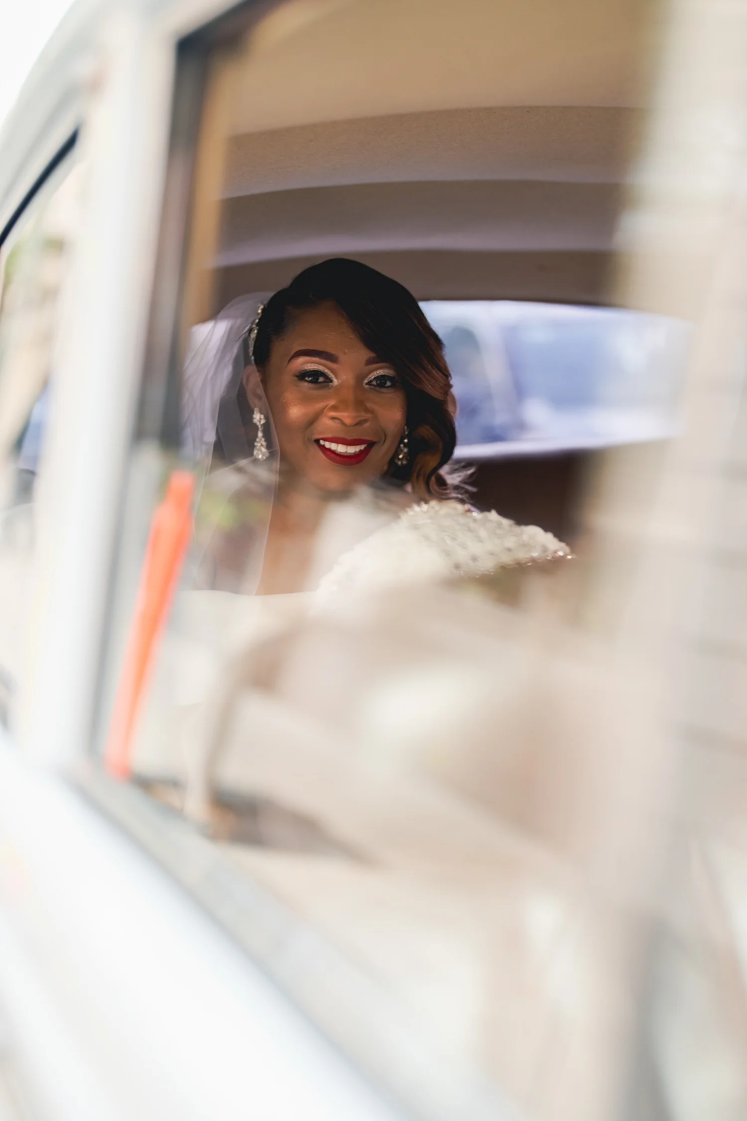 Las Vegas wedding photography — bride with red lipstick looking through a vintage car window