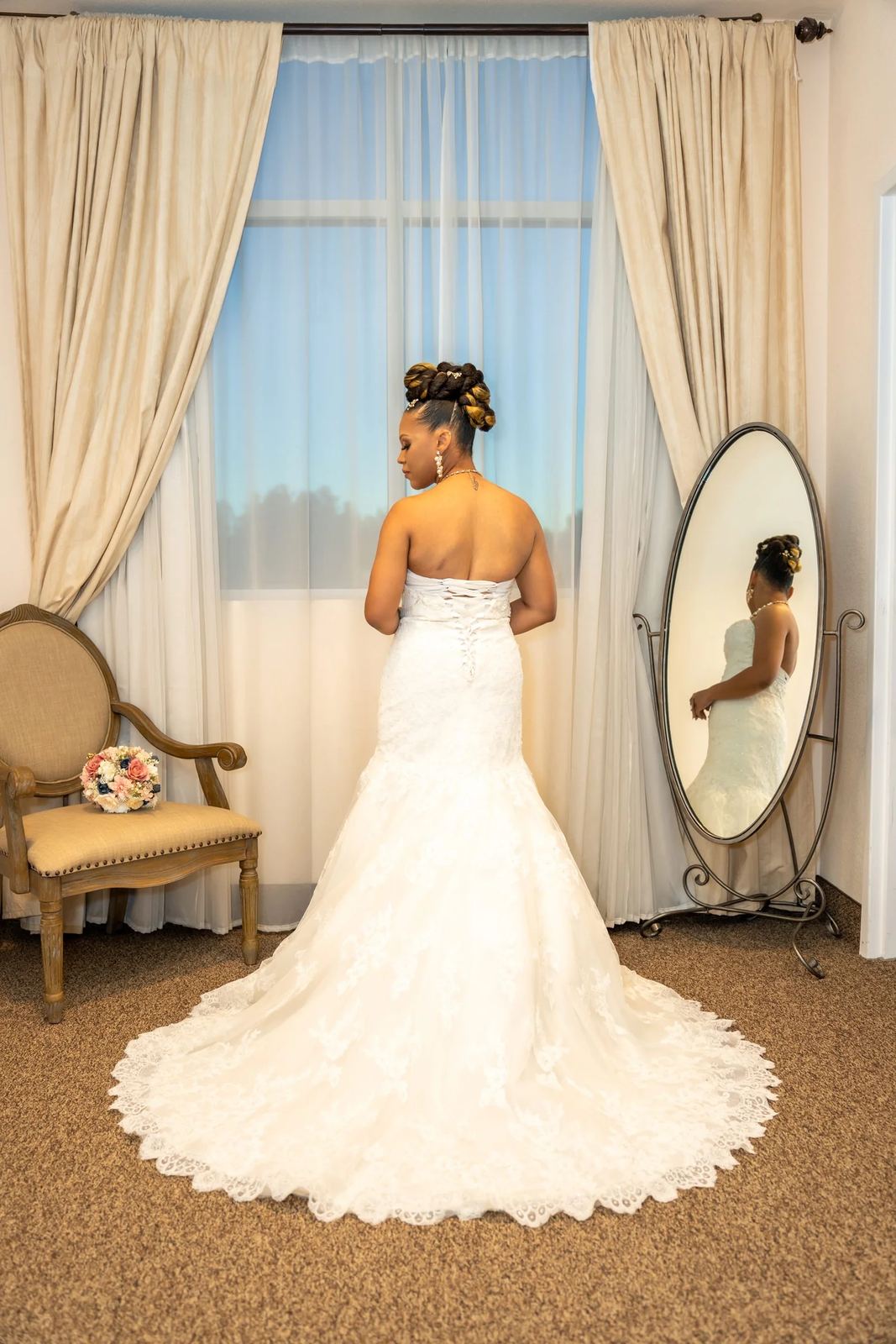 Las Vegas wedding photography — bride in a strapless lace gown at a full-length mirror