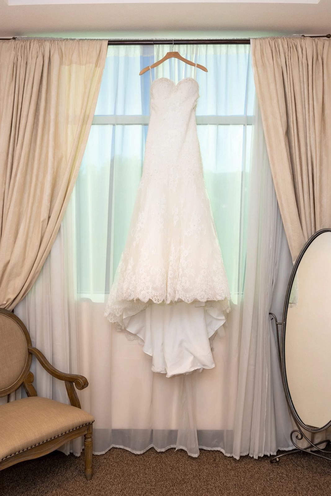 Las Vegas wedding photography — wedding dress on a wooden hanger by the window