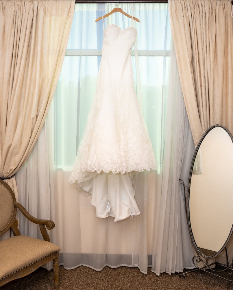 Las Vegas wedding photography — the lace gown hanging by a curtained window