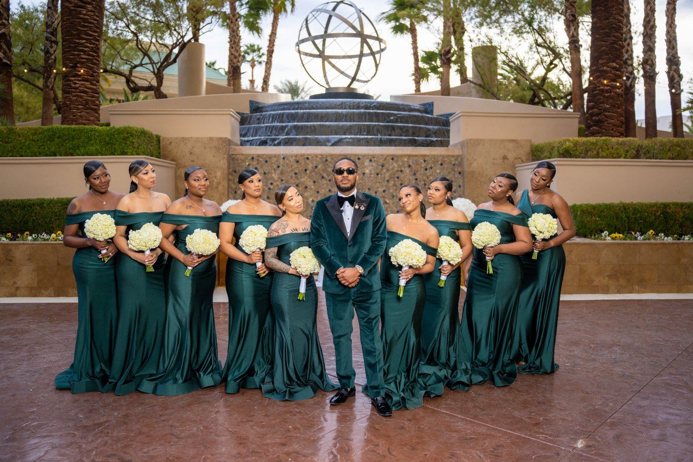 Las Vegas wedding photography — the wedding party in emerald in front of the resort waterfall