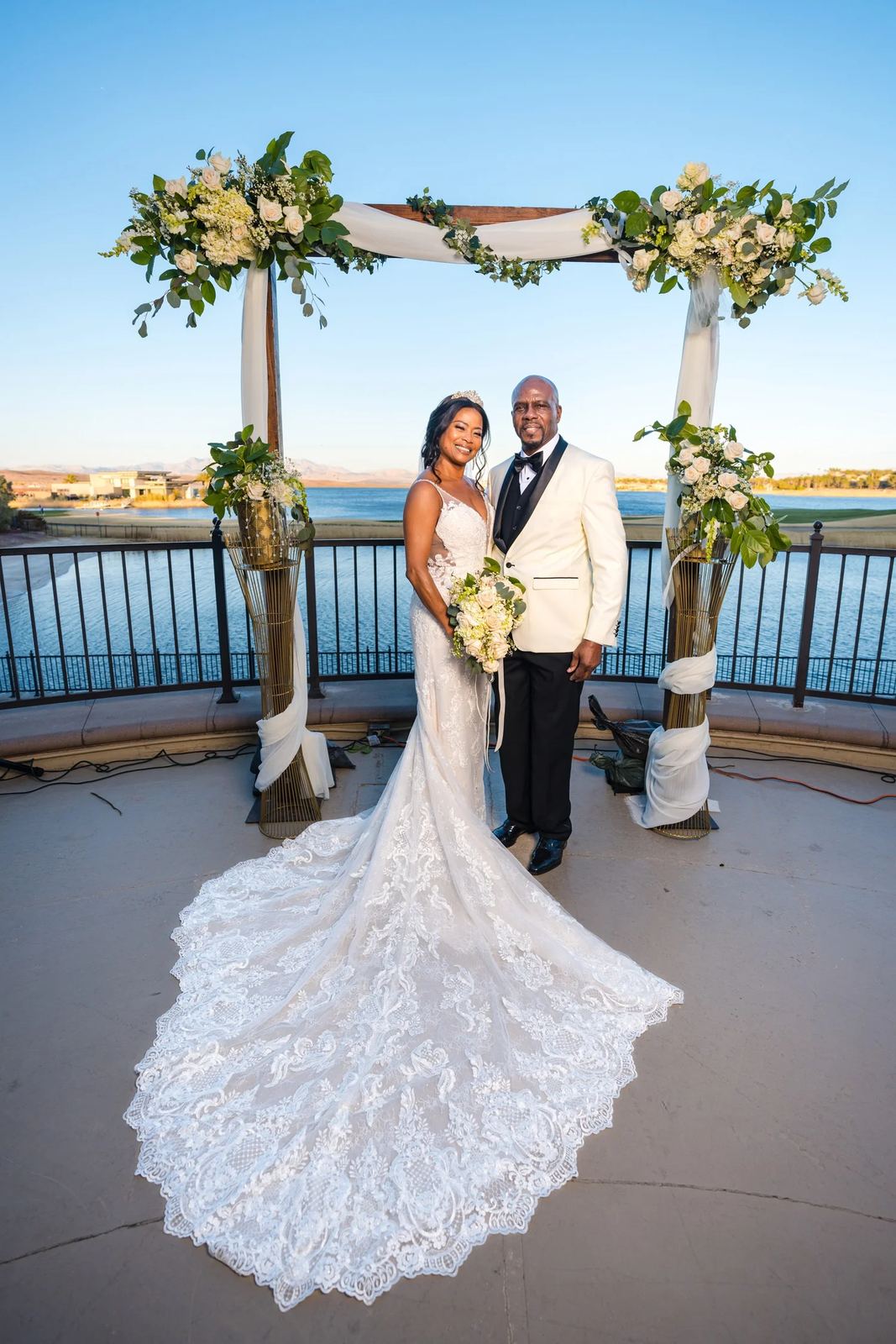 Las Vegas wedding photography — bride and groom under a decorated arch by the lake
