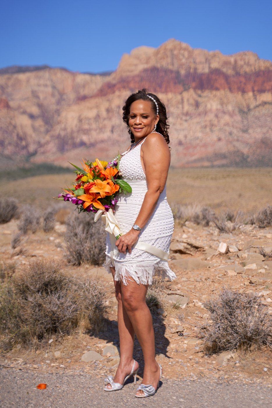 Las Vegas wedding photography — the bride alone with her orange bouquet at Red Rock Canyon