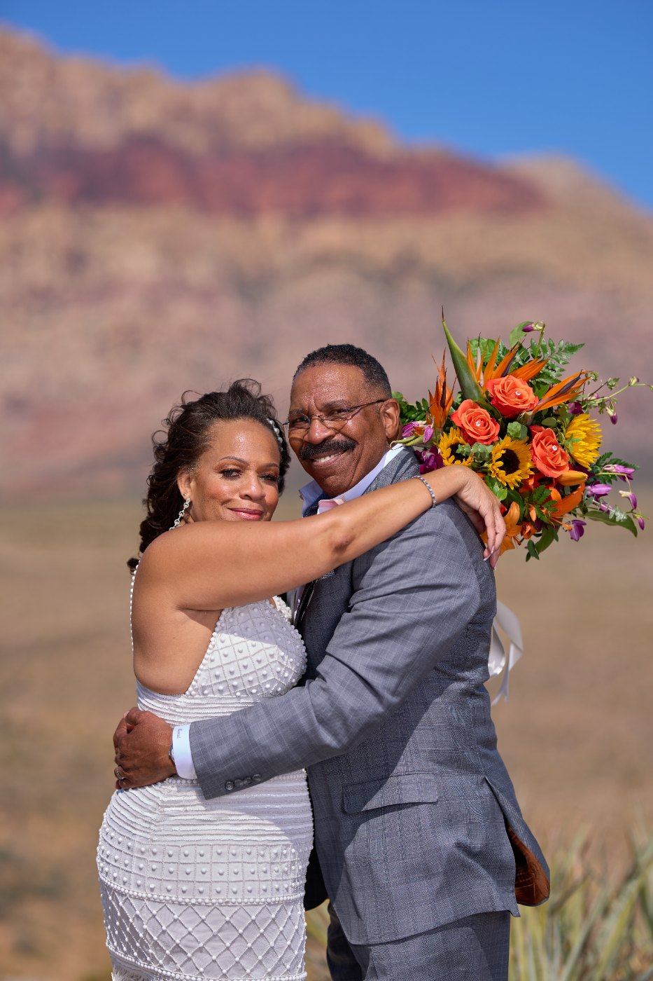 Las Vegas wedding photography — the couple embracing, bouquet still in hand
