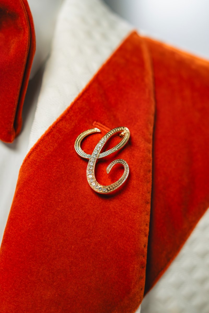 Las Vegas wedding photography — a monogrammed lapel pin resting on a red velvet jacket