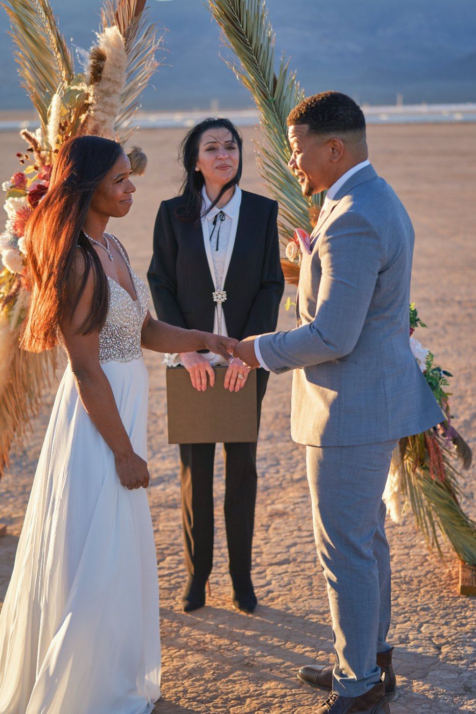 Las Vegas wedding photography — exchanging vows in front of the pampas arch