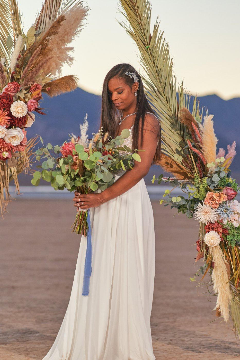 Las Vegas wedding photography — the bride alone at the arch with her bouquet