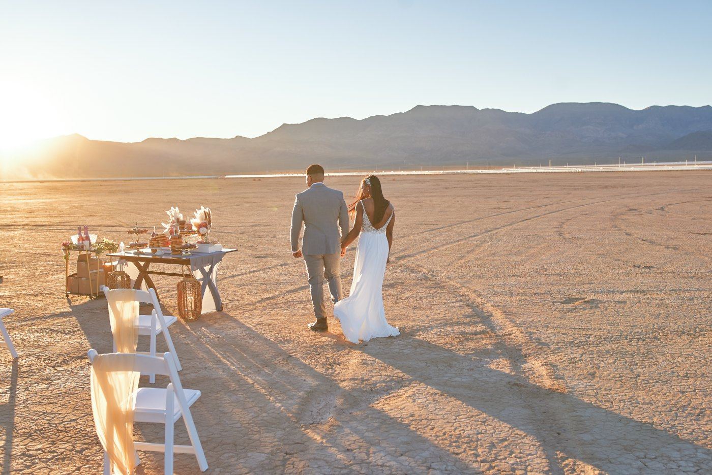 Las Vegas wedding photography — the couple walking away across the flats at sunset