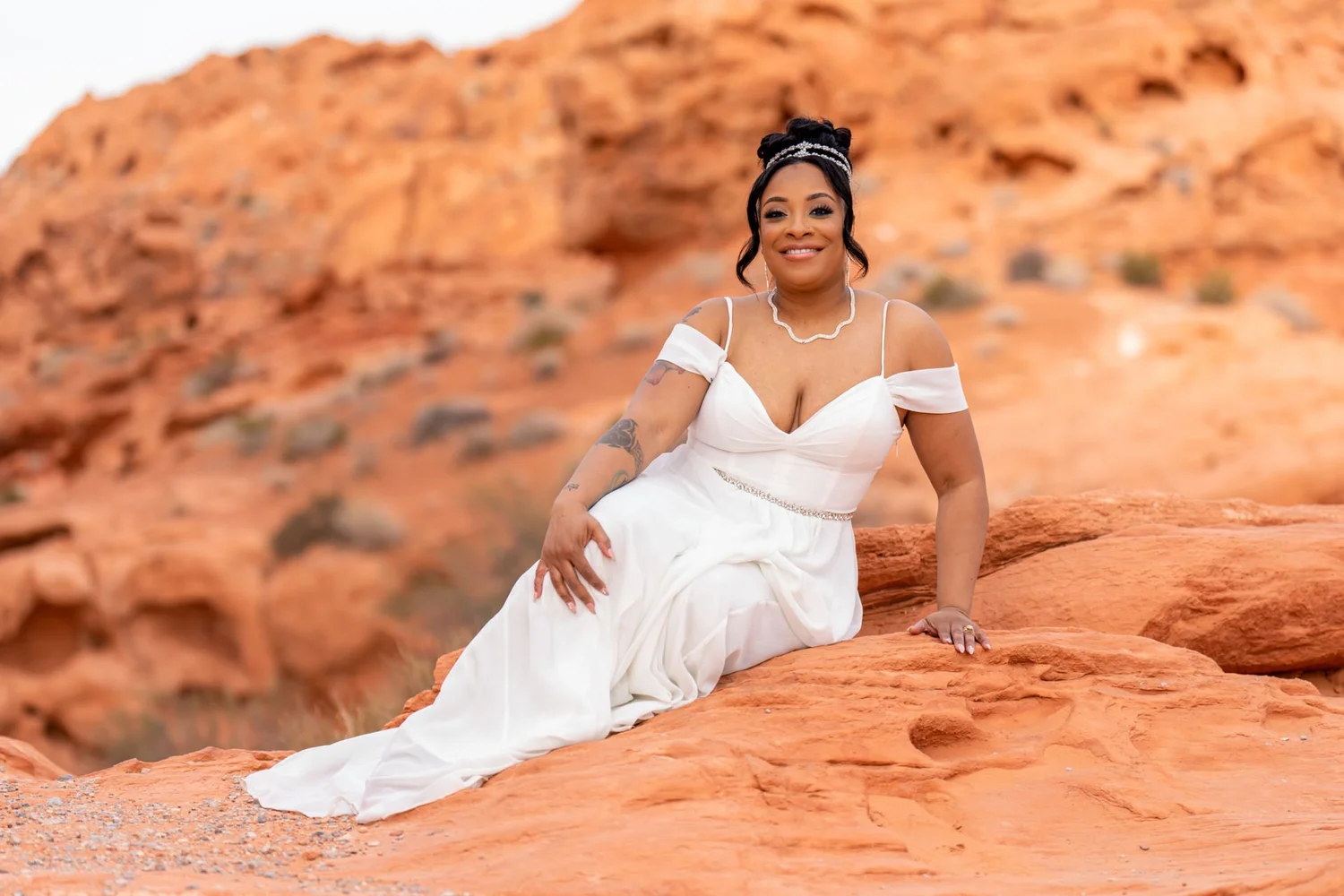 Las Vegas wedding photography — bride in a white gown seated on red rocks