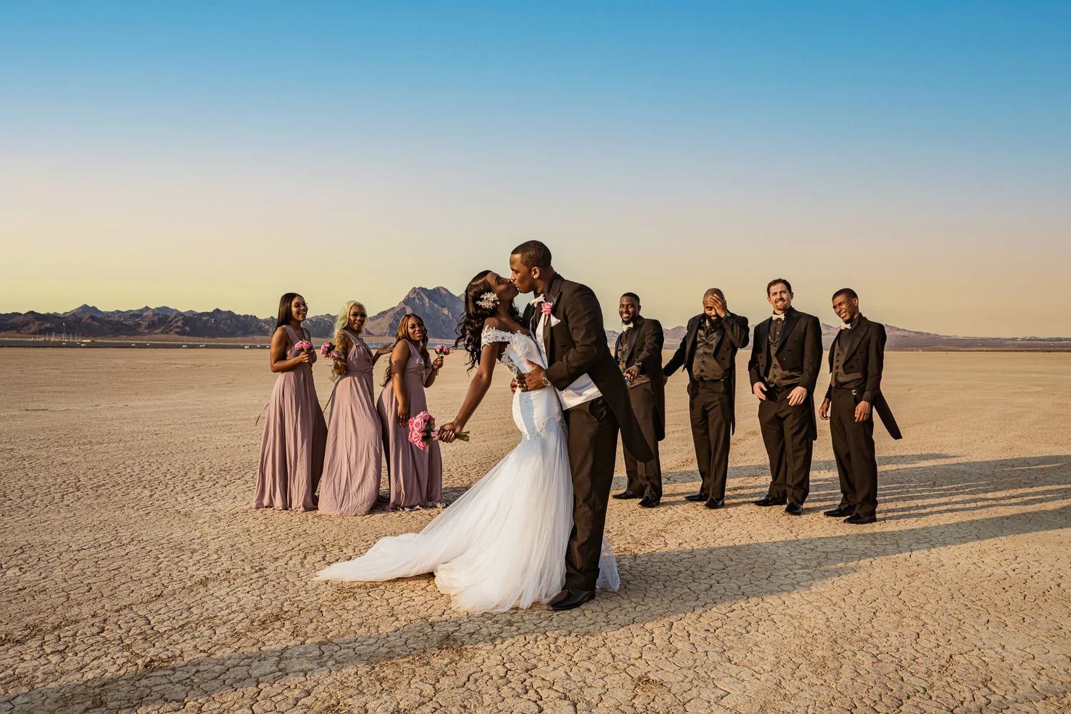 Las Vegas wedding photography — kiss on a dry lake bed with the bridal party around them