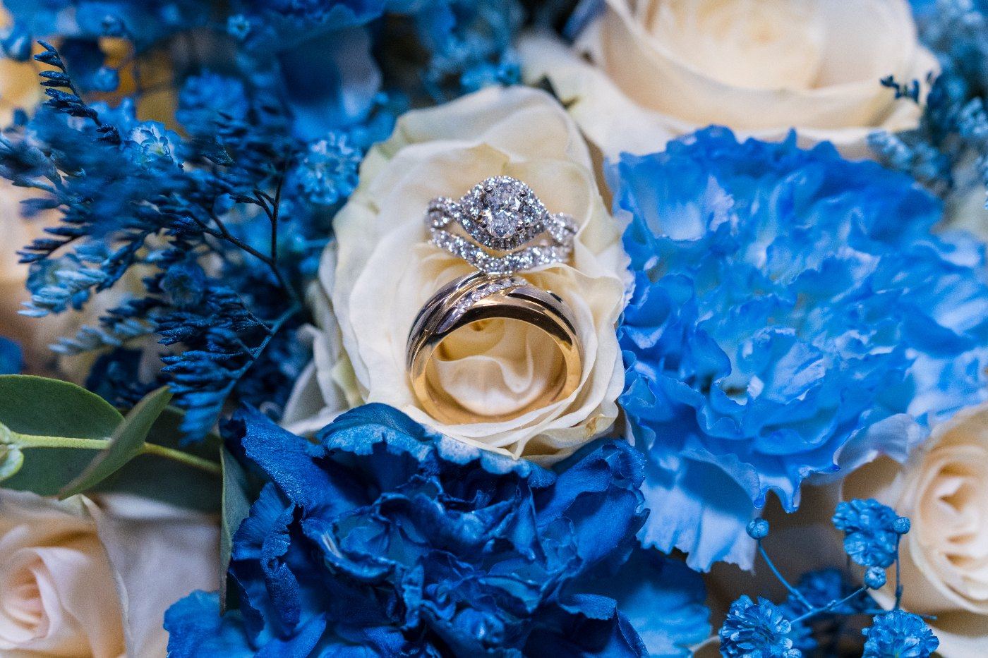 Las Vegas wedding photography — the rings resting on a blue and white rose bouquet