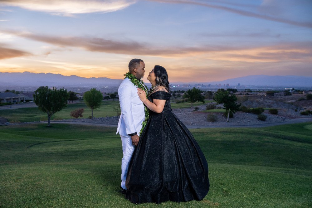 Las Vegas wedding photography — the bride in a black gown and groom in white against a golf course sunset
