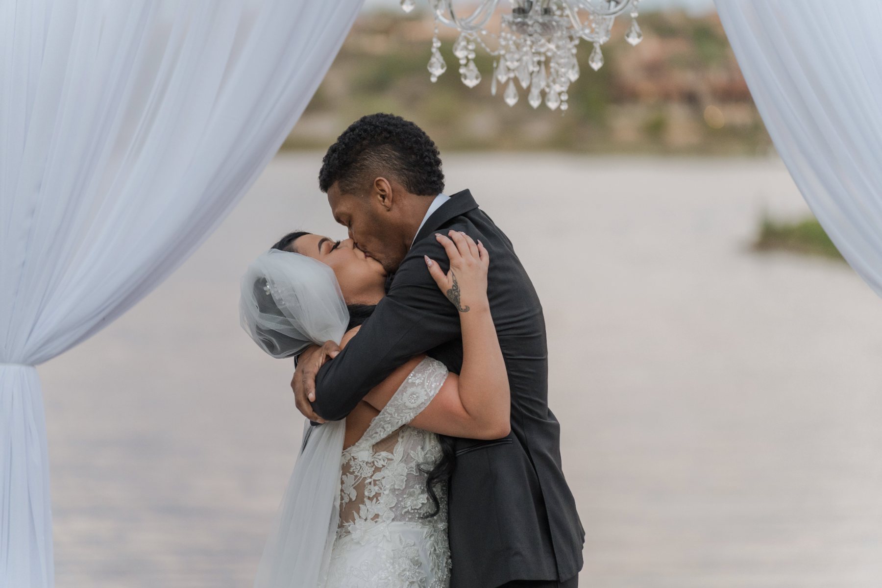 Las Vegas wedding photography — couple embracing under white ceremony drapery