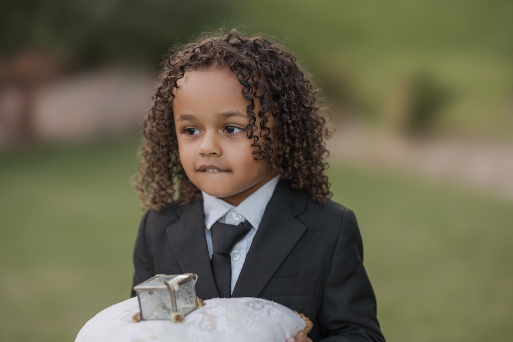 Las Vegas wedding photography — ring bearer in a black suit holding the pillow