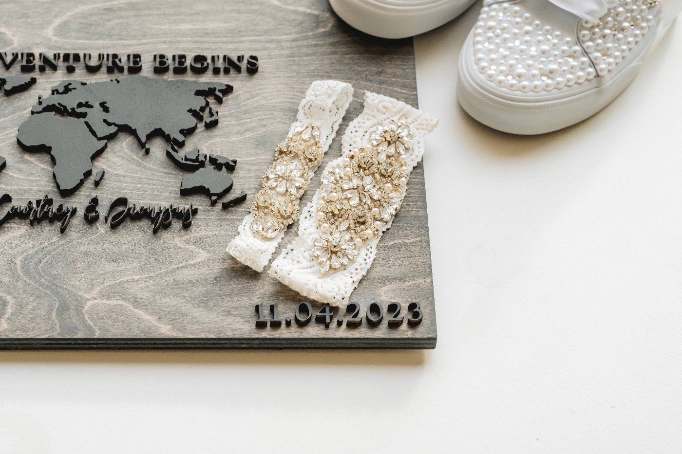 Las Vegas wedding photography — an “adventure begins” world map sign laid out with the shoes and garter