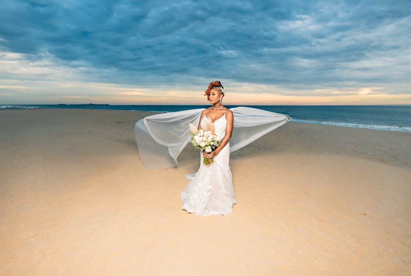 Las Vegas wedding photography — the bride alone on the beach at dusk with her veil out