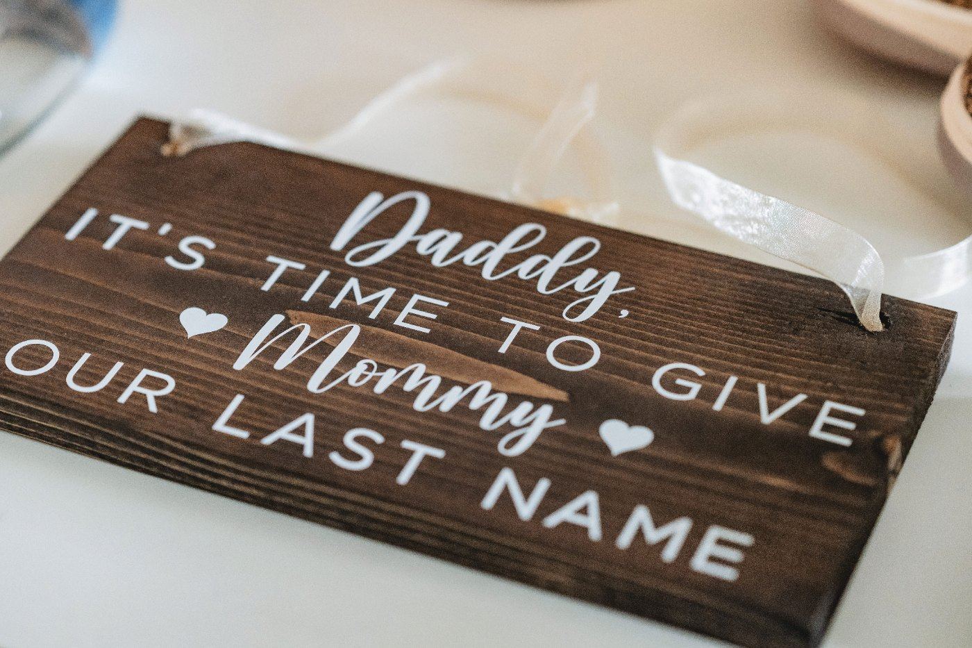 Las Vegas wedding photography — a wooden sign reading “Daddy, it’s time to give Mommy our last name”