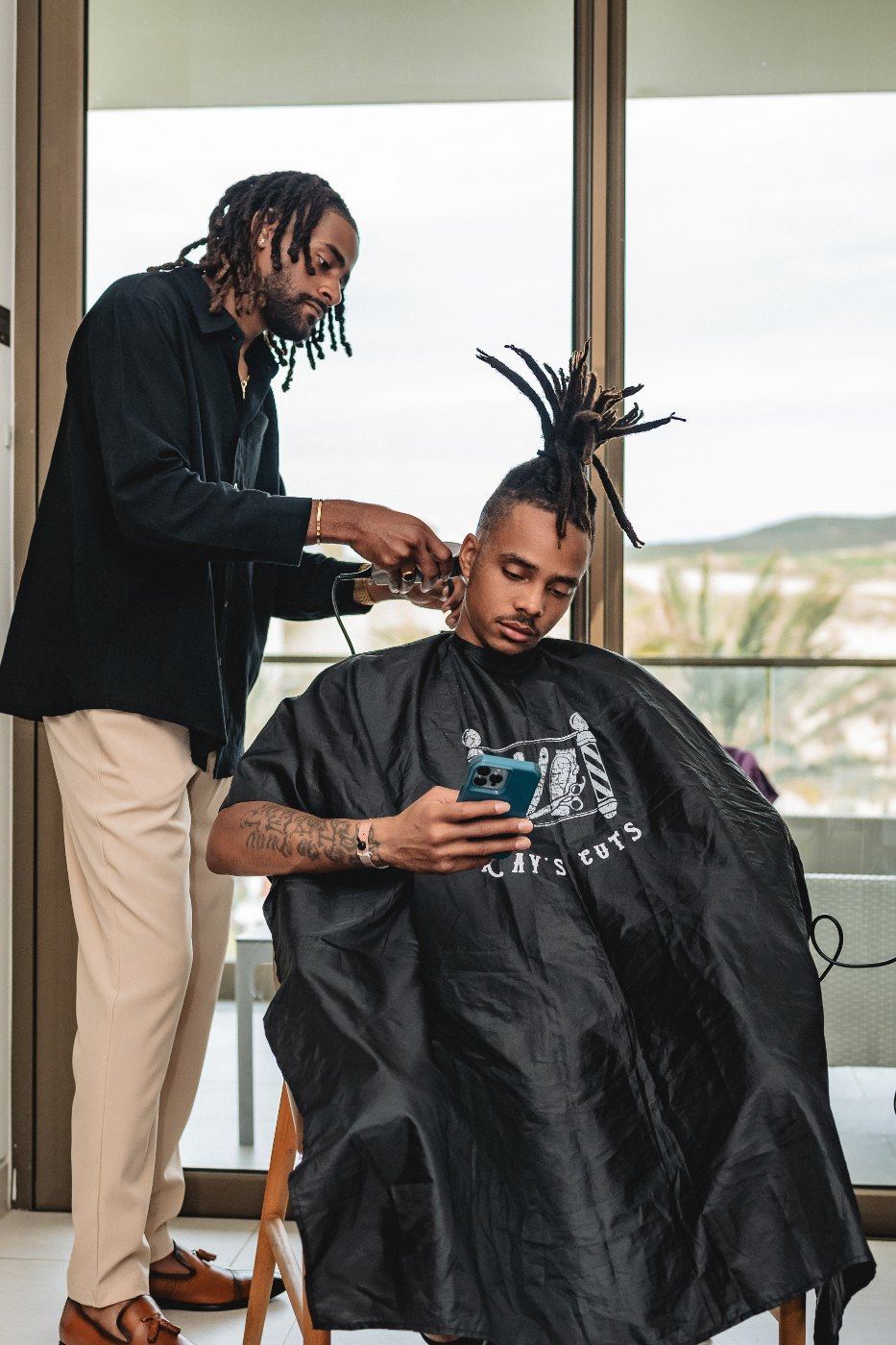 Las Vegas wedding photography — the groom getting a haircut by the window on the morning of
