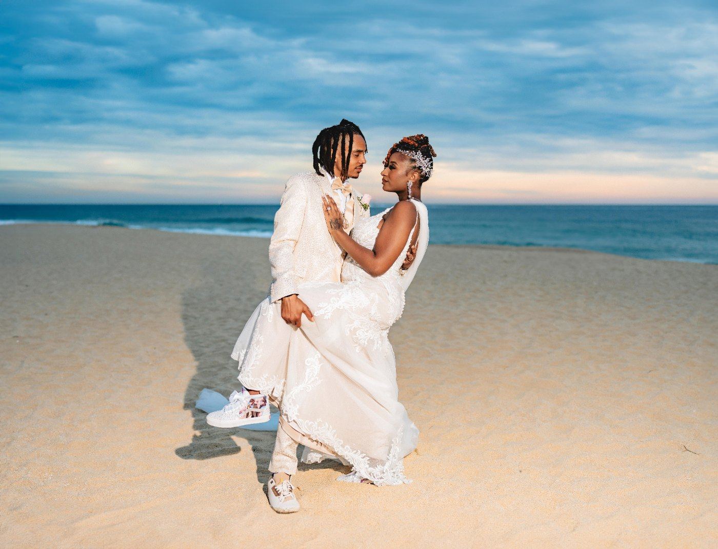 Las Vegas wedding photography — the couple and their daughter together on the sand at sunset