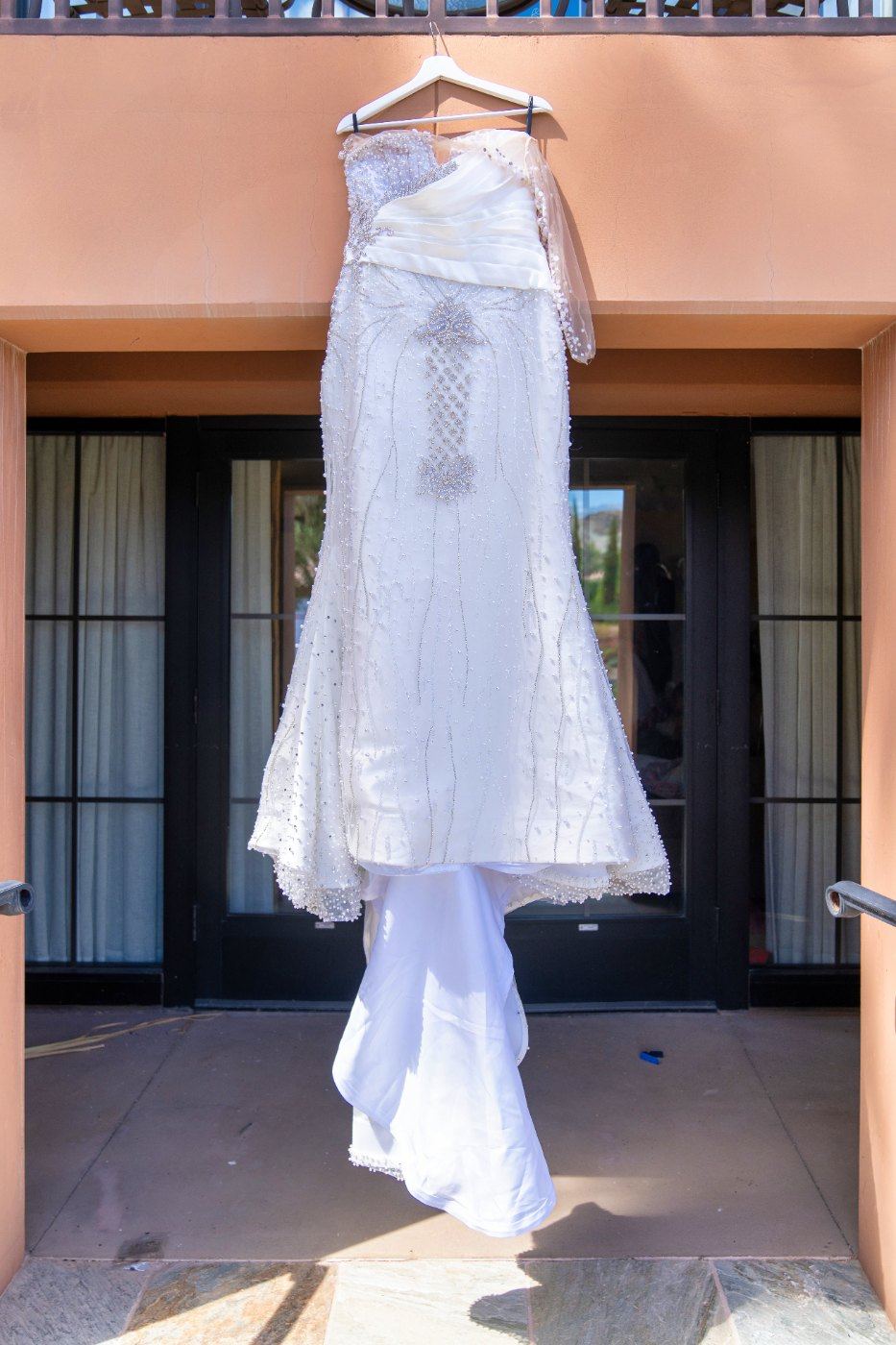 Las Vegas wedding photography — the beaded gown hanging in a sunlit doorway
