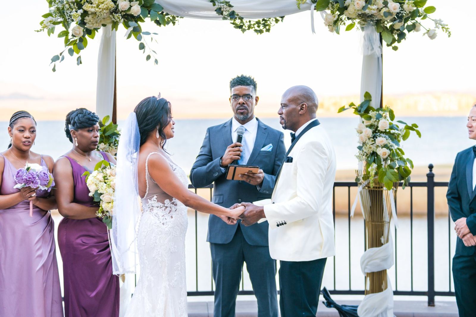 Las Vegas wedding photography — exchanging vows under the floral arch