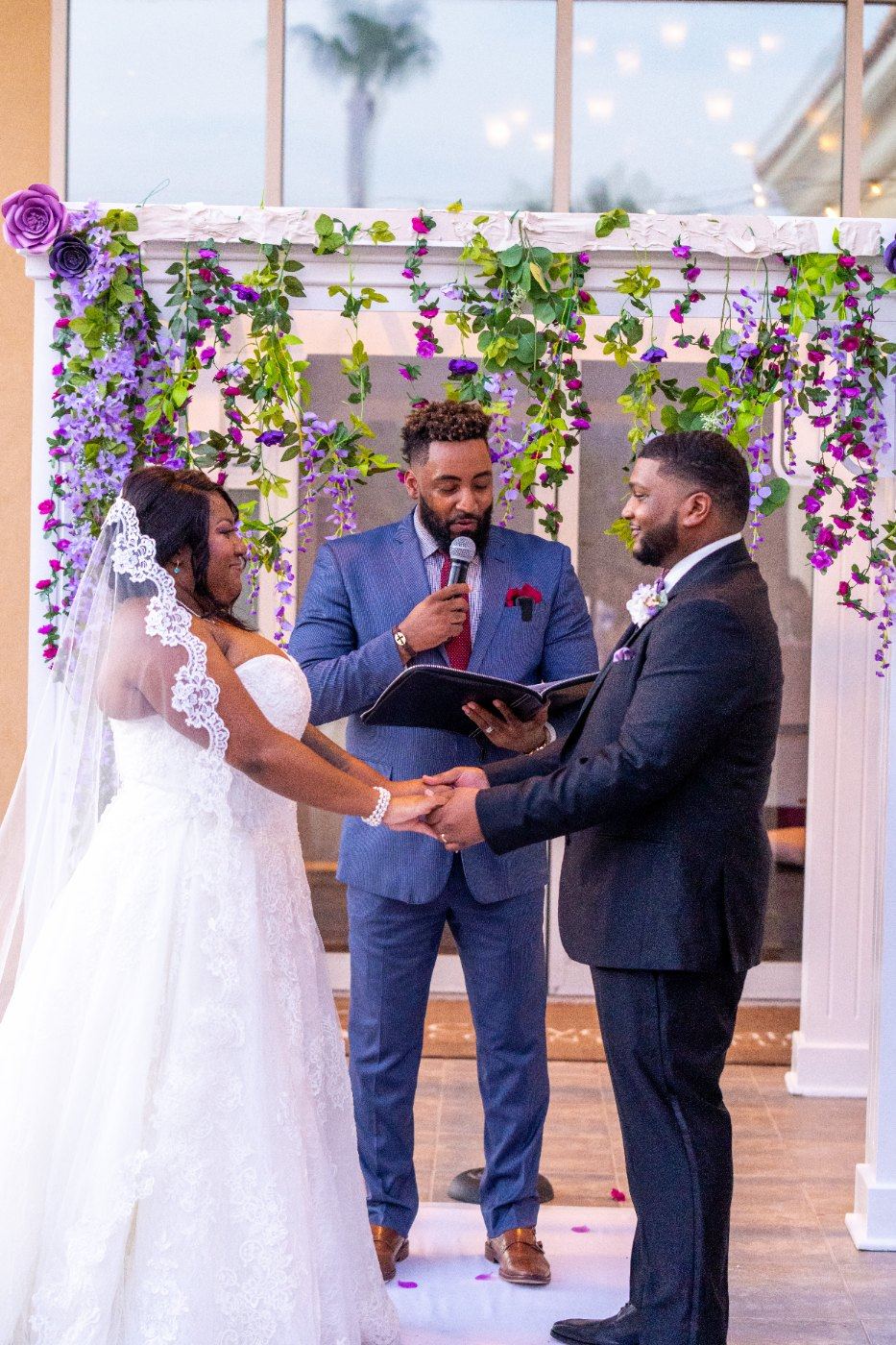 Las Vegas wedding photography — holding hands under the purple floral arch