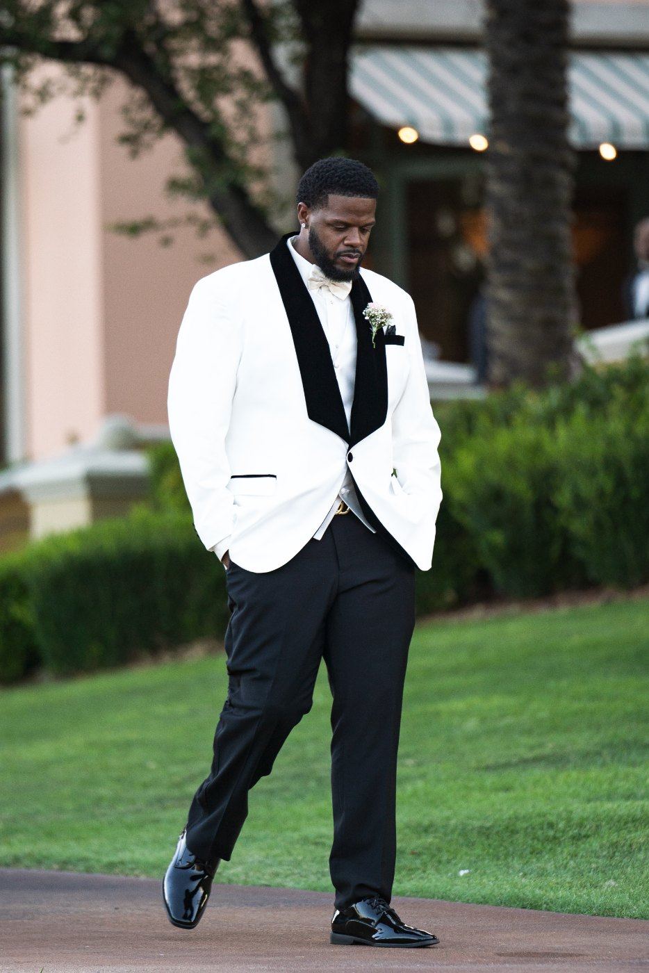 Las Vegas wedding photography — the groom walking in wearing a white tuxedo jacket