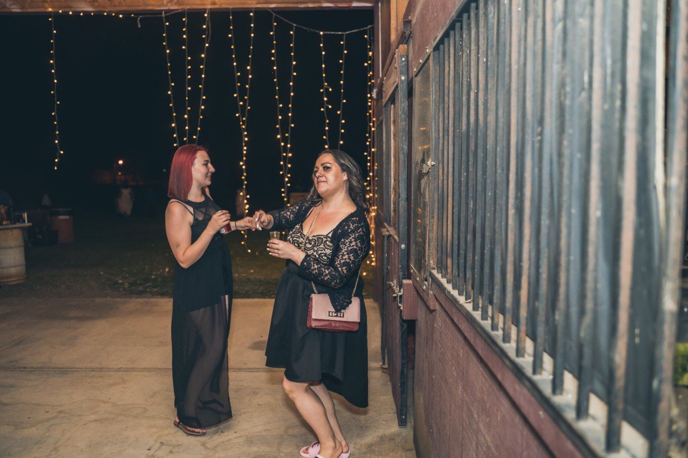 Las Vegas wedding photography — guests talking under string lights outside the barn