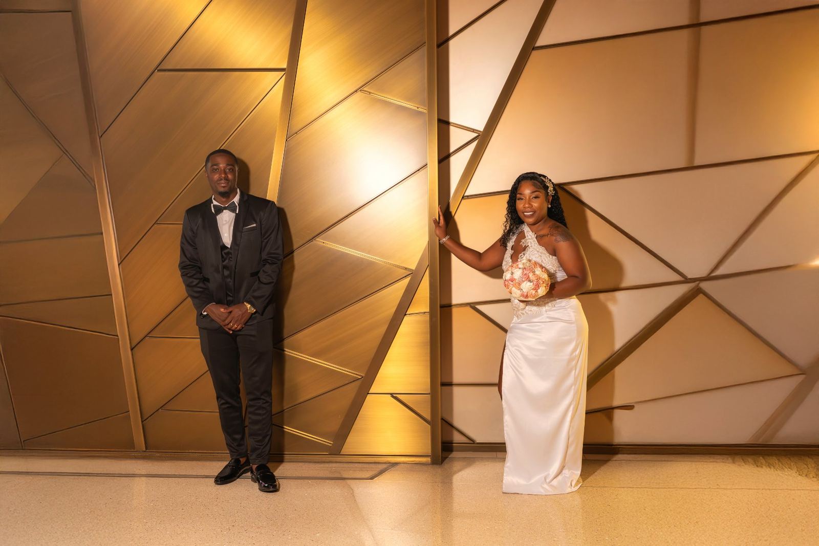 Las Vegas wedding photography — the couple against a gold geometric wall