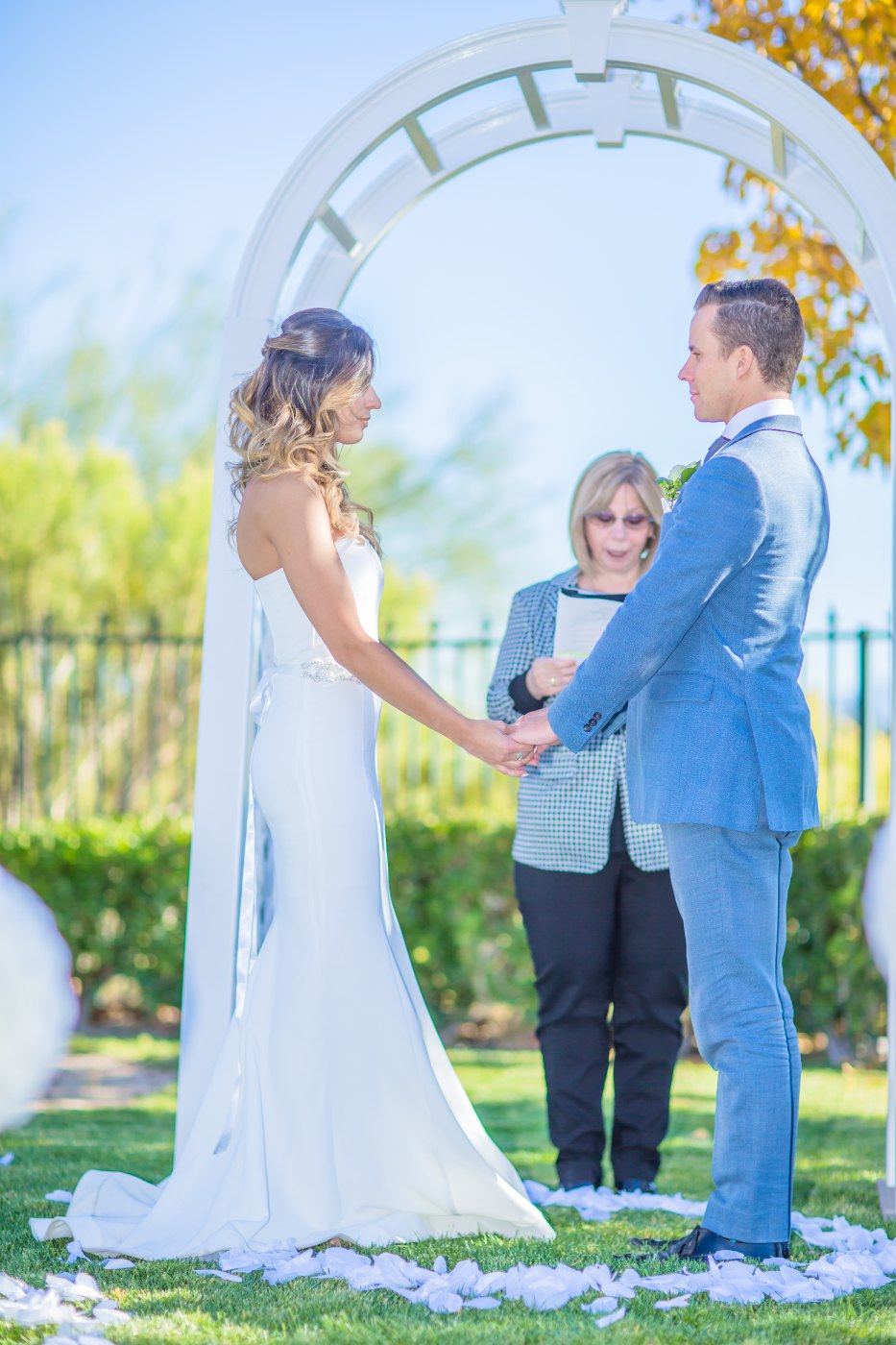 Las Vegas wedding photography — exchanging vows under the white garden arch