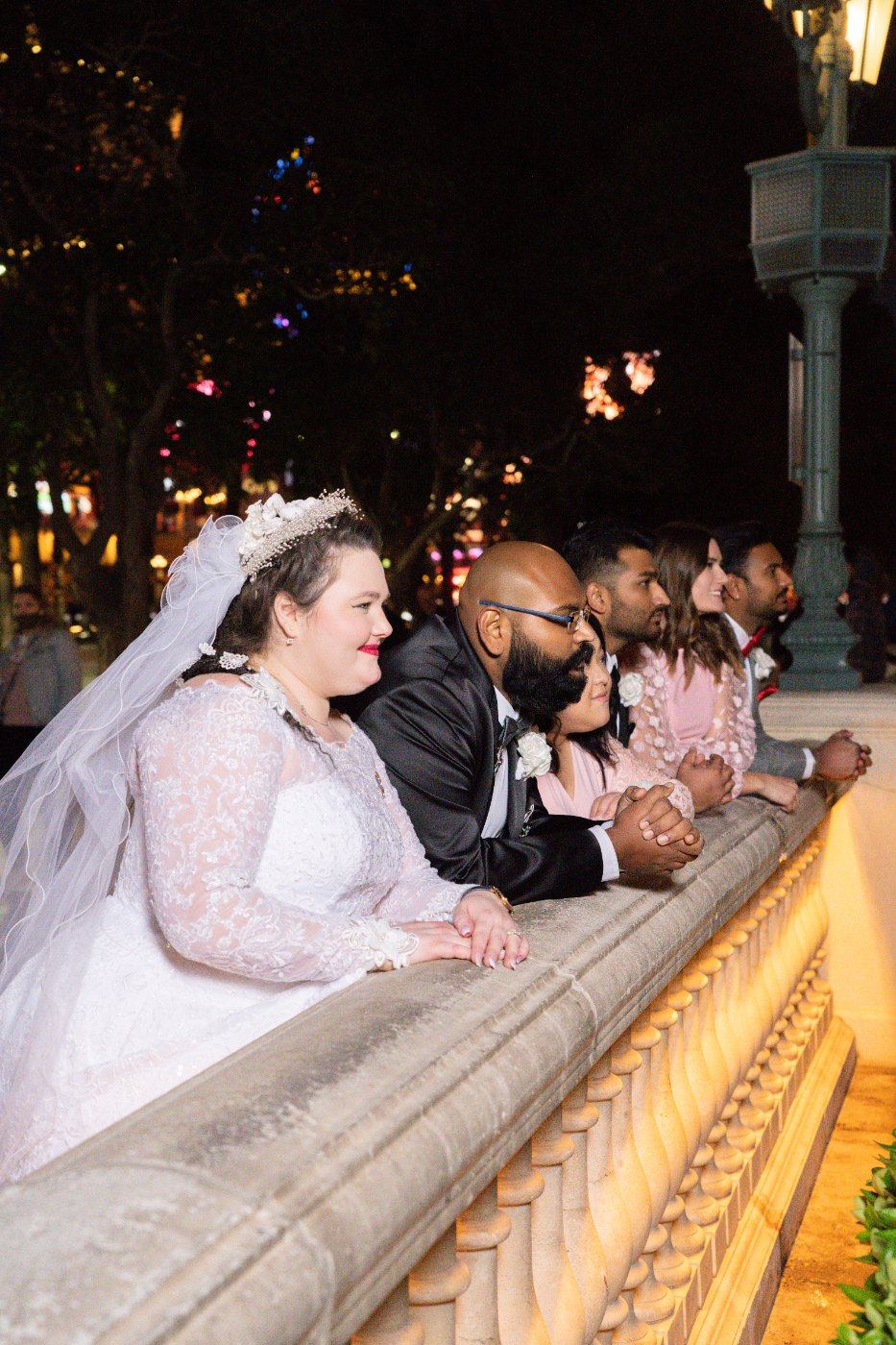 Las Vegas wedding photography — the wedding party leaning on the railing at night
