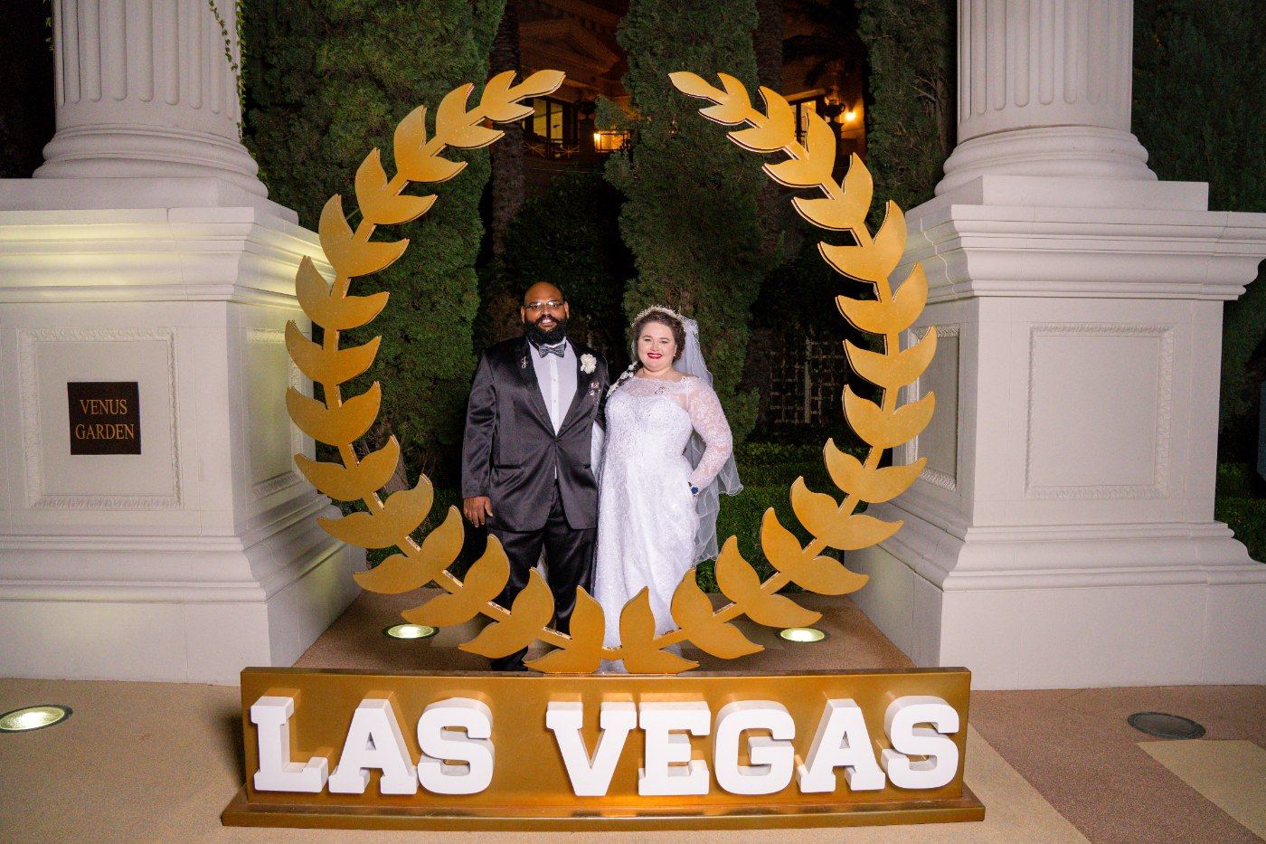 Las Vegas wedding photography — the couple under the gold Las Vegas sign at Caesars