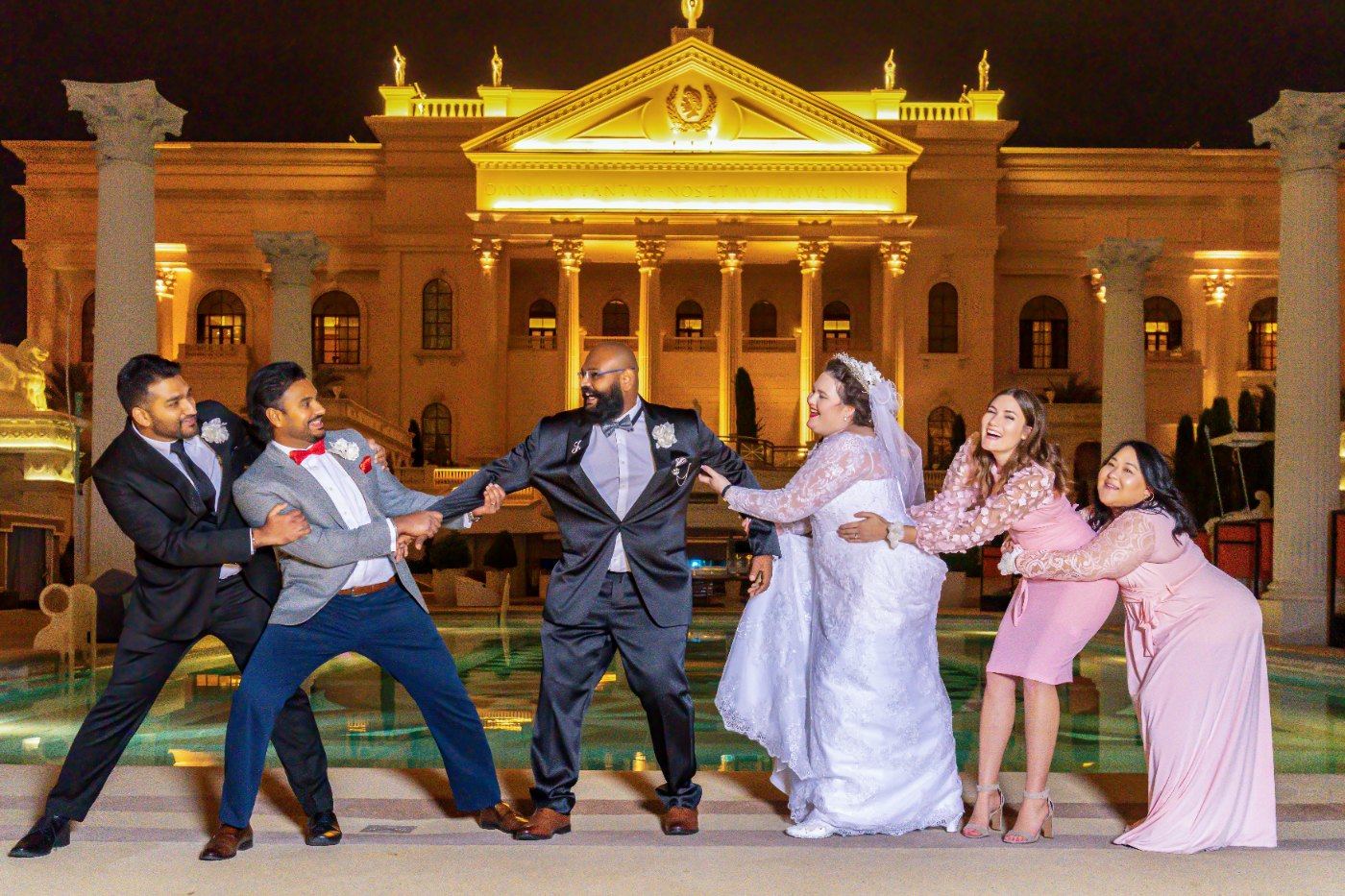 Las Vegas wedding photography — the wedding party clowning around by the fountain