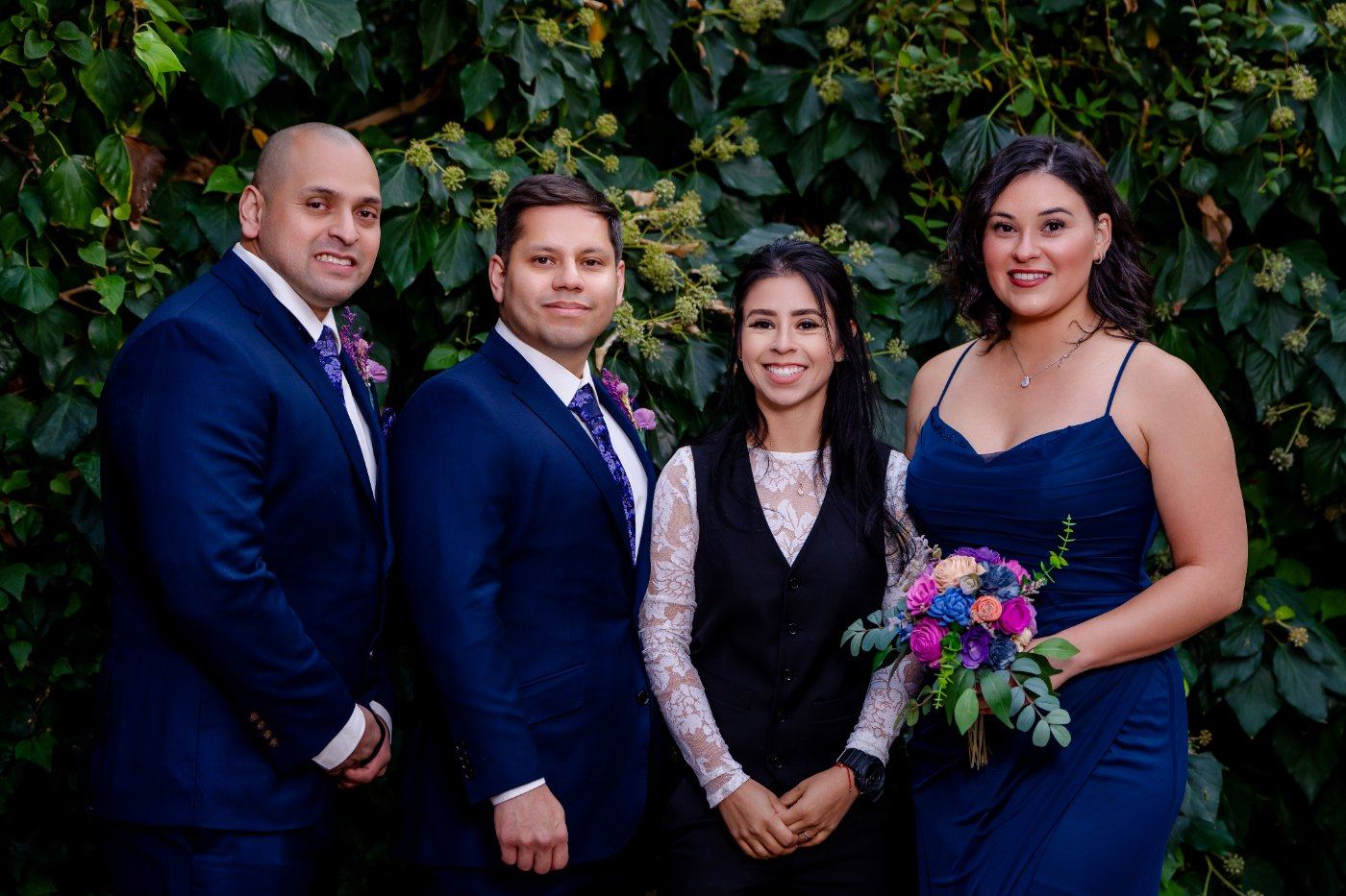 Las Vegas wedding photography — the full wedding party in navy and purple against a green wall