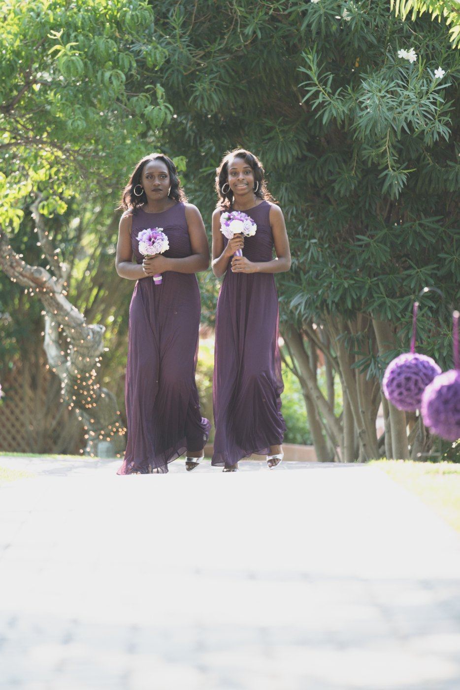 Las Vegas wedding photography — bridesmaids in purple walking the garden aisle