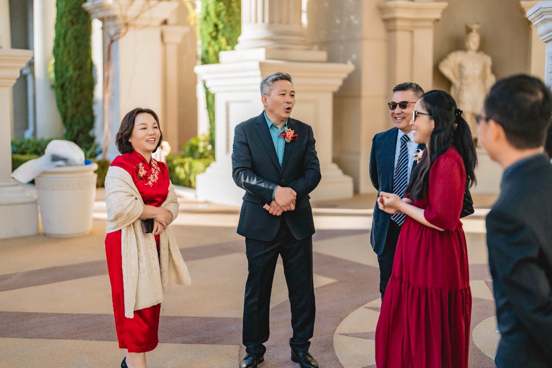 Las Vegas wedding photography — parents in red chatting with guests before the ceremony